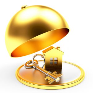 Key with house on golden tray with open lid isolated on white background